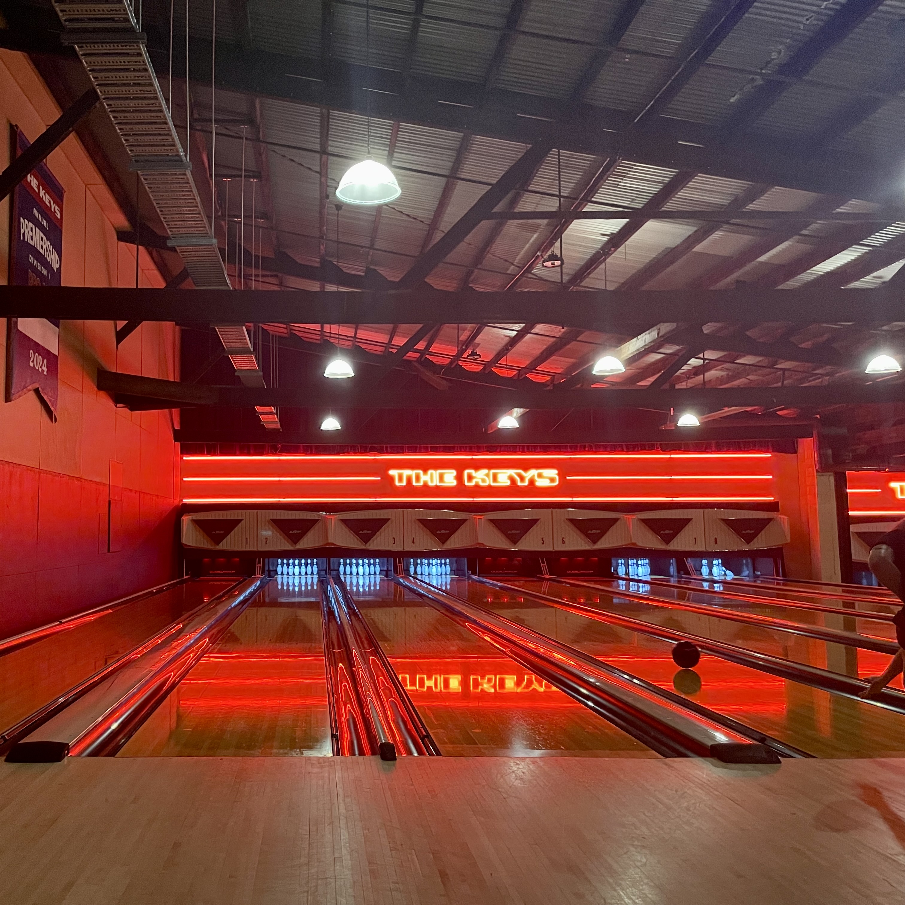 A bowling alley with a neon sign that says "the keys"